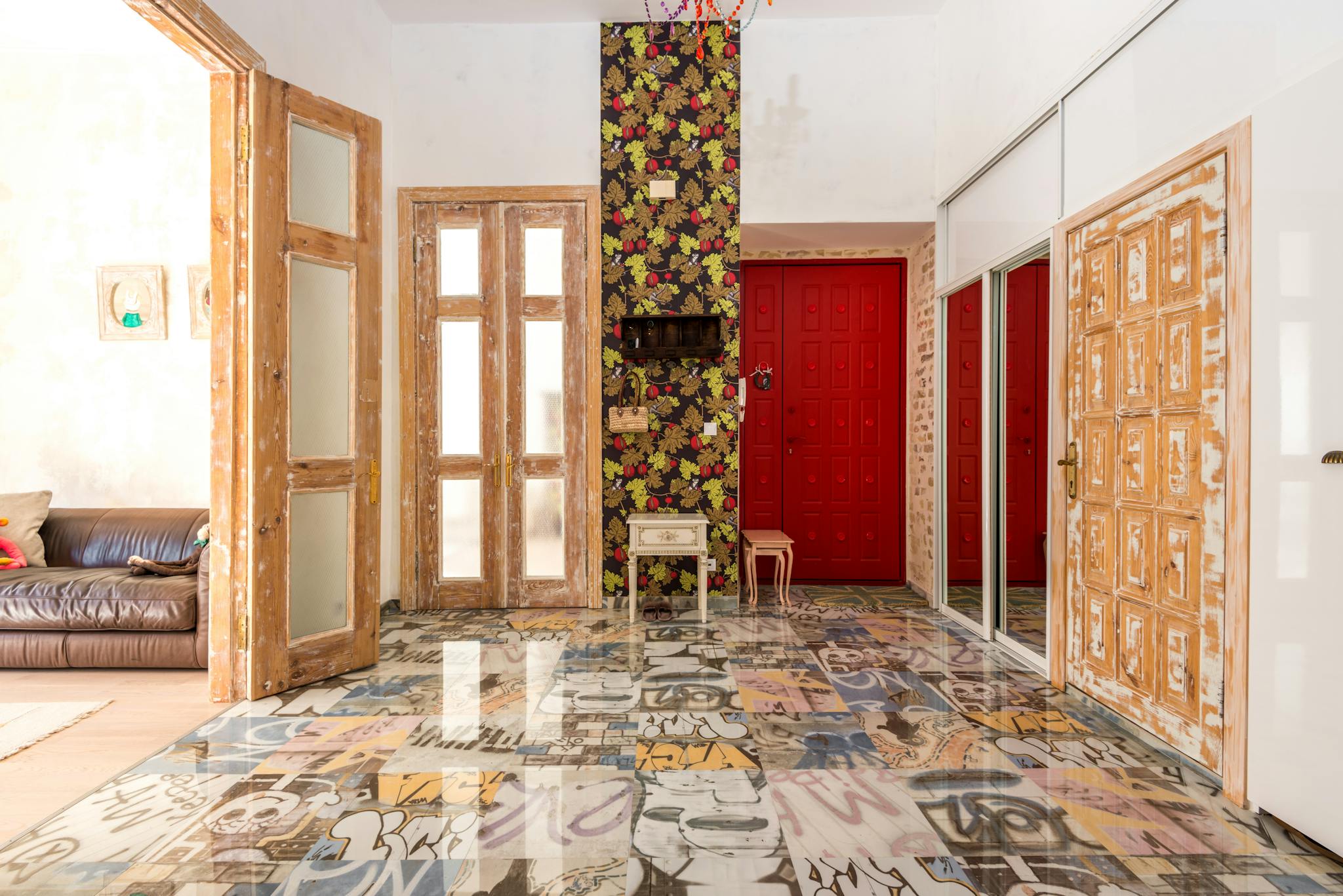 Vibrant and eclectic interior featuring floral wall, graffiti floor, and rustic wood doors.